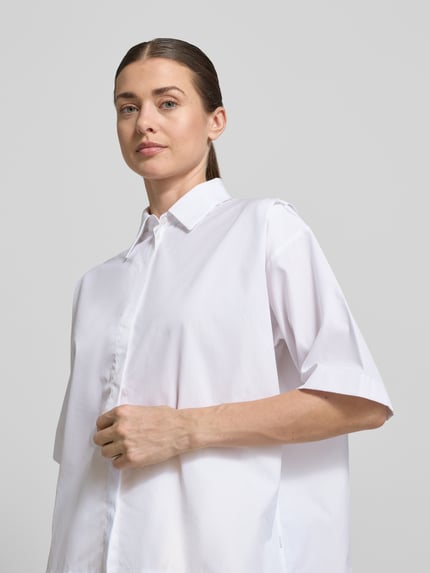 Frauenmodel trägt Oversized Hemdbluse aus reiner Baumwolle Modell 'BIMINA' von BOSS, unifarben, Popeline, Nahaufnahme Oberkörper.