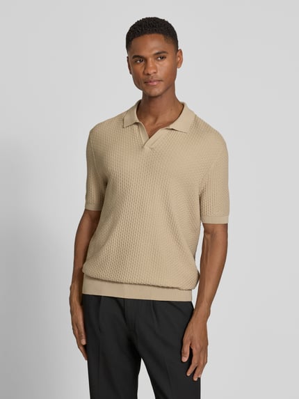 Männermodel trägt Regular Fit Poloshirt aus reiner Baumwolle Modell 'NATALO' von BOSS in Beige, Piqué-Struktur, Ganzkörperansicht von vorne.