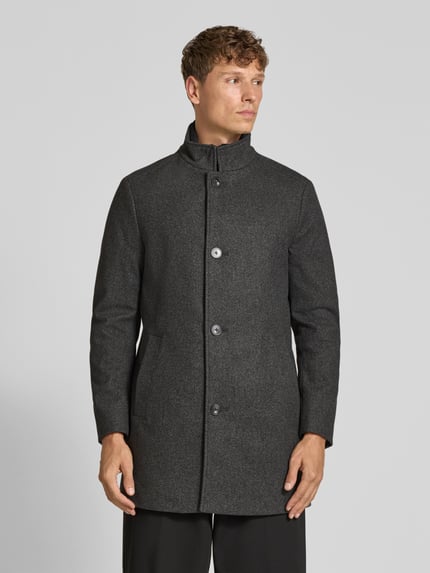 Männermodel trägt Mantel mit Stehkragen Modell 'TRISTAN' von MC NEAL, dunkelgrau, unifarben mit Strukturmuster, Ganzkörperansicht von vorne.