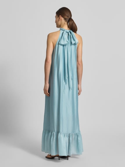 Modelka nosi sukienkę koktajlową 'Cocktailkleid mit rückseitiger Schnürung' od Jake*s Cocktail z mieszanki lyocellu, asymetryczny krój, długa sukienka, efekt stopniowania, długość tyłu w rozmiarze 36: 145 cm, szerokość w rozmiarze 36: 52 cm, widok całej sylwetki z tyłu.
