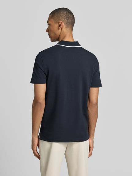 Männermodel trägt Modern Fit Poloshirt mit Logo-Stitching van Christian Berg Men in donkerblauw, katoen, polokraag, ruglengte maat M 71 cm, ganzkörperansicht rückansicht.