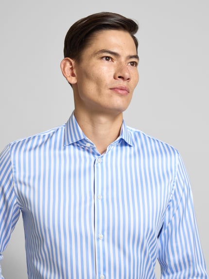 Mannmodel draagt Slim Fit Businesshemd aus katoen met extra lange mouw van Jake*s, blauw-wit gestreept, haaikraag, knoopsluiting, Nahaufnahme bovenlichaam. Ruglengte 71 cm, schouderbreedte 44 cm, mouwlengte 69 cm, puur katoen.