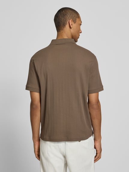 Männermodel trägt Regular Fit Poloshirt reiner Baumwolle Modell 'COLE' von SELECTED HOMME in Braun mit Struktur-Jersey, Ganzkörperansicht Rückansicht.