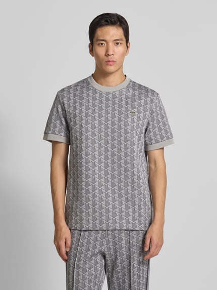 Männermodel trägt Regular Fit T-Shirt mit Baumwoll-Anteil von Lacoste, Optik: Unifarben, Muster: L-Monogramm, Logo-Patch, Ganzkörperansicht von vorne.