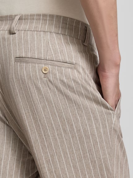 Männermodel trägt Hose mit Label-Detail Modell 'Orlando' von CG - Club of Gents aus Material-Mix mit Viskose-Anteil, Detailaufnahme.