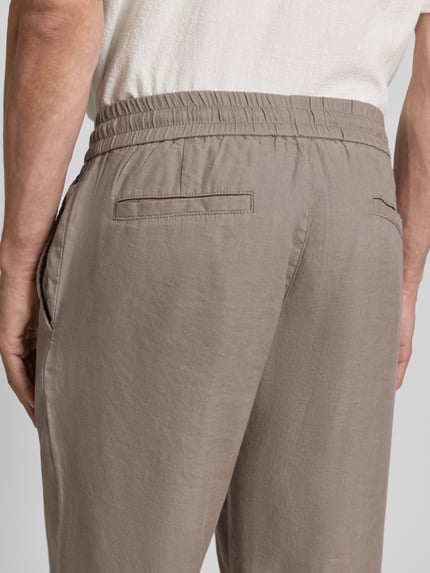 Männermodel trägt Straight Fit Schmale Hose aus Leinen-Lyocell-Mix Modell 'CINO' von HUGO, Optik: Unifarben, Nahaufnahme Rückansicht.