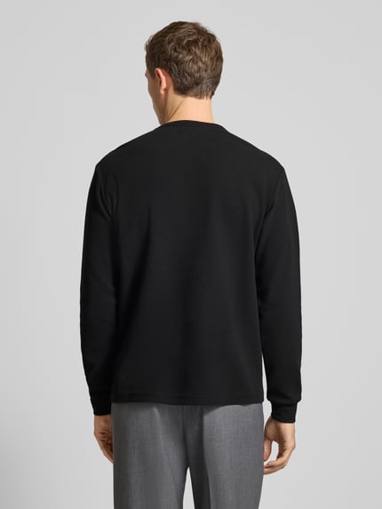 Männermodel trägt Regular Fit Pullover mit Knopfleiste Modell 'Kilano' von Drykorn, Baumwoll-Mix, Strukturmuster, Rückenansicht.