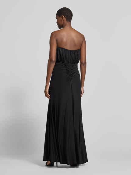 Frauenmodel trägt Abendkleid mit geraffter Frontpartie von Self-Portrait in Schwarz, Maxi-Länge, Jersey, Volant-Saum, Ganzkörperansicht Rückansicht.