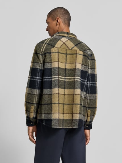 Männermodel trägt Hemdjacke mit Brusttasche von Barbour aus Wollmix, kariert, mehrfarbig, langarm, Rückansicht, Ganzkörperansicht.