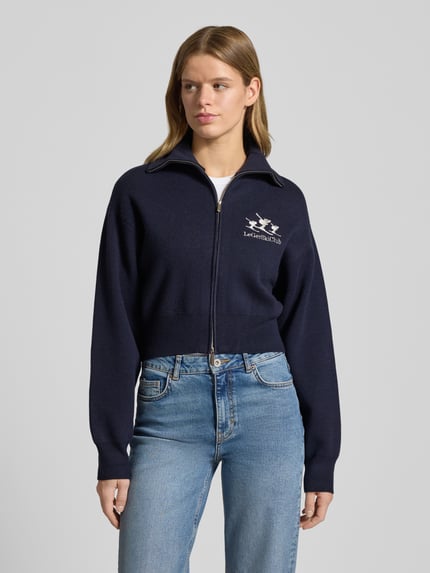 Frauenmodel trägt Cropped Strickjacke aus Viskose-Mix Modell 'Jaden' von LeGer by Lena Gercke in Dunkelblau mit Stitching, Zweiwege-Reißverschluss, Ganzkörperansicht von vorne.
