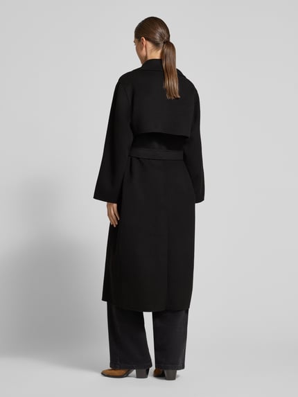 Frauenmodel trägt schwarzen Regular Fit Mantel aus Schurwoll-Mix Modell 'OPEROSO' von Weekend Max Mara, Ganzkörperansicht Rückansicht.