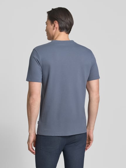 Männermodel trägt Regular Fit T-Shirt aus Baumwoll-Mix Modell 'TIBURT 240' von BOSS, unifarben, Mouliné-Garn, Ganzkörperansicht Rückansicht.