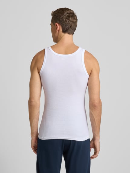 Męski model nosi Tanktop in Ripp-Optik od Götzburg Bielizna, bawełna, krój slim fit, efekt prążkowania, okrągły dekolt. Ganzkörperansicht Rückansicht.
