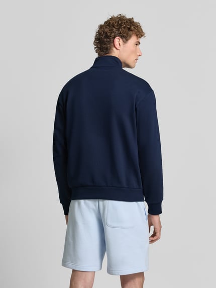 Männermodel trägt Regular Fit Troyer aus Baumwoll-Mix von Lacoste in Dunkelblau, glatte Oberfläche, Ganzkörperansicht Rückansicht. Herren Troyer von Lacoste