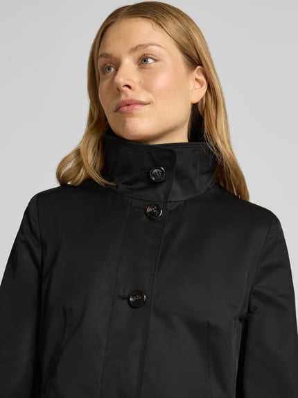 Modelka nosi Kurzmantel mit Stehkragen und Pattentaschen von Gil Bret, czarny, mieszanka bawełny, krój slim fit, zapięcie na guziki, patki, długość tyłu w rozmiarze 36: 86 cm, szerokość ramion w rozmiarze 36: 39 cm, szerokość klatki piersiowej w rozmiarze 36: 46 cm, długość rękawa w rozmiarze 36: 65 cm, zbliżenie na górę sylwetki