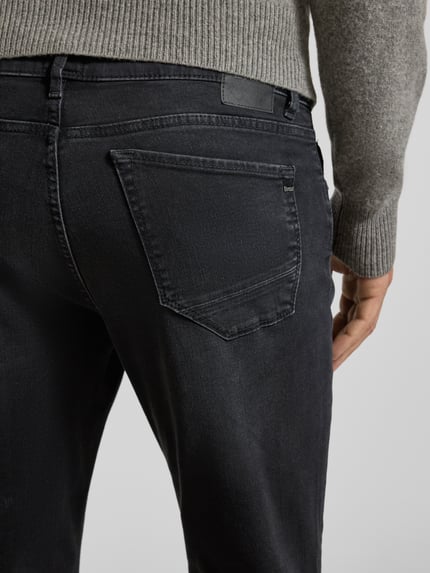 Männermodel trägt Jeans im Used-Look Modell 'Chuck' von Brax aus Baumwoll-Mix im Regular Fit, Detailaufnahme Rückansicht.