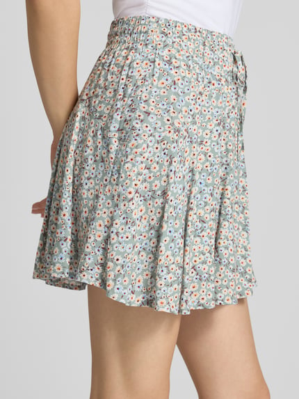 Vrouwenmodel draagt Mini-Skort uit pure viscose model 'NALA LIFE' van Only, licht uitlopende fit, all-over bloemenprint, elastische taille, detailopname zijkant.