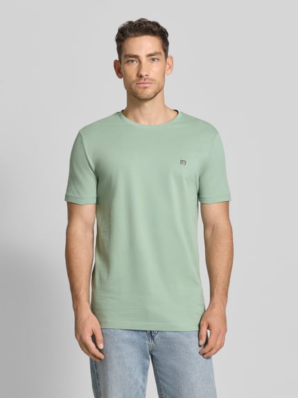 Männermodel trägt T-Shirt aus Baumwolle mit Rundhalsausschnitt von Christian Berg Men in Mint, Regular-Fit, Label-Detail, Ganzkörperansicht von vorne. Rückenlänge bei Größe M: 71 cm, Reine Baumwolle.