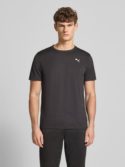 Männermodel draagt T-Shirt met logo en ronde hals van PUMA PERFORMANCE, regular fit, zwart, maat M, voorkant, Ganzkörperansicht von vorne.