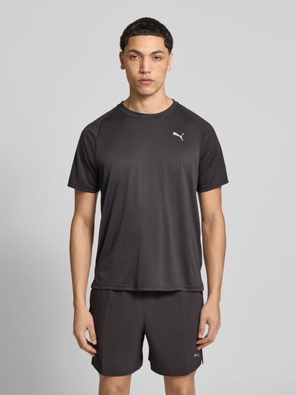 Męski model nosi T-Shirt mit Logo und Rundhalsausschnitt von PUMA PERFORMANCE, kolor czarny, krój regular fit, widok całej sylwetki z przodu.