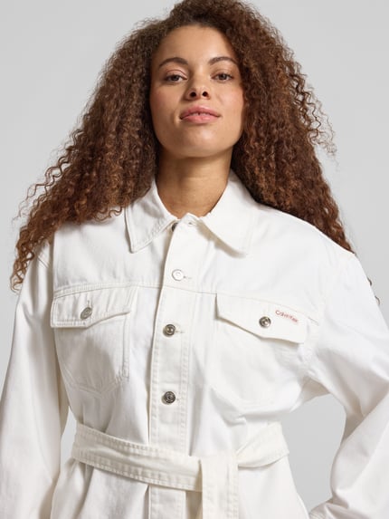 Kobiece model nosi Regular Fit Jeansjacke mit abnehmbarem Taillenband od Calvin Klein Jeans, biała bawełna, naszywka z logo, szerokość w rozmiarze S: 54 cm, długość tyłu: 66 cm, szerokość ramion: 60 cm, długość rękawa: 56 cm, zbliżenie górnej części ciała