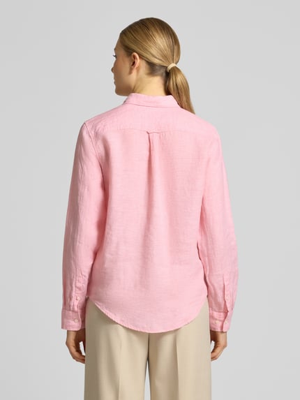 Modelka nosi Regular Fit Leinenbluse mit Label-Stitching von Gant, różowy len, kołnierzyk koszulowy, listwa guzikowa, długość tyłu 66 cm, długość rękawów 60 cm, widok całej sylwetki z tyłu.