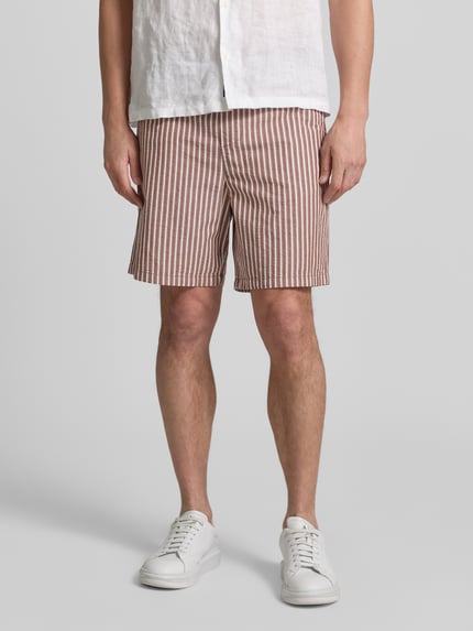 Männermodel trägt Regular Fit Shorts aus reiner Baumwolle Modell 'STUART' von SELECTED HOMME, Seersucker, Optik: Unifarben, Nahaufnahme Unterkörper.