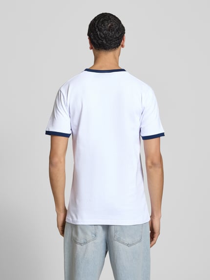 Männermodel trägt T-Shirt mit Logo- und Label-Patch Modell 'RINGETTO' von Ellesse, Reine Baumwolle, Gerader-Schnitt, Rückenlänge 72 cm, Ganzkörperansicht Rückansicht.