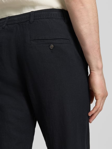 Männermodel trägt Regular Fit Hose aus Baumwoll-Leinen-Mix Modell 'BRODY' von SELECTED HOMME, Melange-Optik, Detailaufnahme Rückansicht.