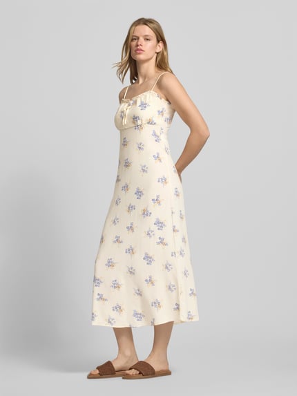 Frauenmodel trägt schmales Freizeitkleid aus reiner Viskose Modell 'NELLY' von Only mit Allover-Muster, Midi-Länge, Henley-Ausschnitt, Spaghettiträgern, Animal-Print, Popeline-Textur; Ganzkörperansicht von vorne.