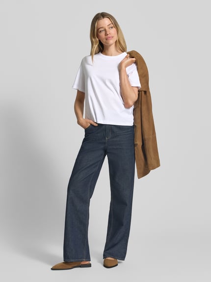Frauenmodel trägt Regular Fit T-Shirt aus reiner Baumwolle Modell 'ASSIA' von Selected Femme in Weiß, unifarben, Rundhals, Ganzkörperansicht von vorne.
