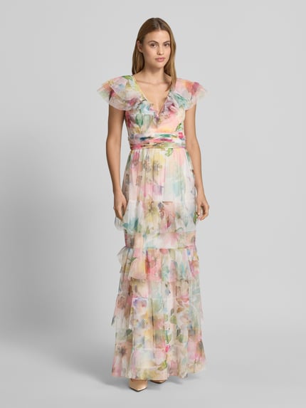 Frauenmodel trägt Maxikleid im Stufen-Look mit Taillenband von LACE & BEADS aus Mesh, pastellfarbene Muster, V-Ausschnitt, taillierter Schnitt, Ganzkörperansicht von vorne.