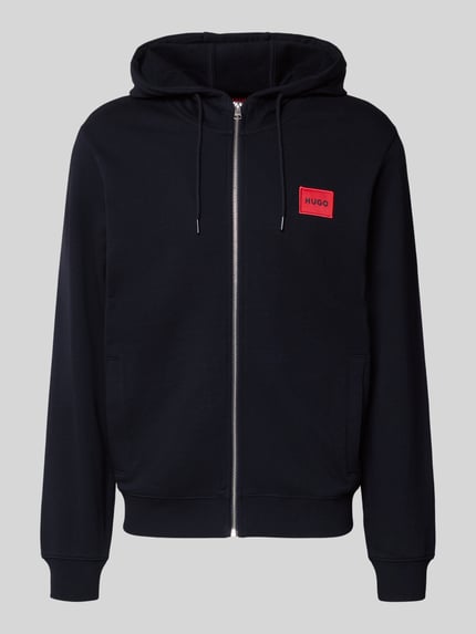 Produktfoto, schwarze Sweatjacke aus Baumwolle Modell 'Daple212' von HUGO, rotes Label-Patch, Kapuze, lockerer Schnitt, Reißverschluss, seitliche Eingrifftaschen.