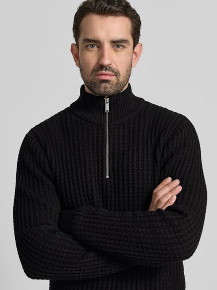 Männermodel trägt Regular Fit Troyer in Waffel-Struktur Modell 'TOM' van SELECTED HOMME in zwart, geribde zoom, bio-katoen, Nahaufnahme Oberkörper.