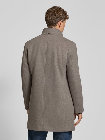 Męski model prezentuje płaszcz z wpuszczanymi kieszeniami, stójką i listwą guzikową, krój regular fit, bugatti, beżowa faktura, długość tyłu 92 cm, szerokość ramion 45 cm, szerokość w rozmiarze 50 55 cm, długość rękawów 62 cm, płaszcz z kolekcji bugatti, całkowity widok z tyłu.
