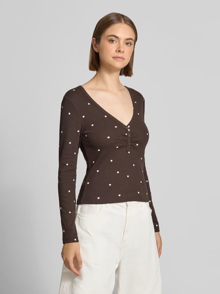 Frauenmodel trägt Regular Fit Langarmshirt aus Baumwoll-Mix Modell 'FENJA' von ONLY, braun mit weißen Punkten, Ganzkörperansicht von vorne, Damen Langarmshirt von ONLY.