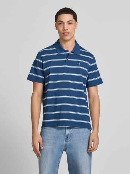 Męski model nosi Regular Fit Poloshirt mit Logo-Stitching von Calvin Klein Jeans z bawełny, krój regular fit, kołnierzyk polo, listwa guzikowa, wyhaftowane logo, długość tyłu w rozmiarze M 69 cm, góra w paski; całkowity widok z przodu.