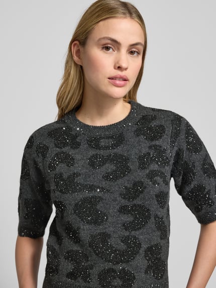 Kobiece model nosi Shaped Fit Strickpullover mit Woll-Anteil Modell 'ZUZU 2/4 O-NECK PULLOVER' od Vero Moda, szara abstrakcyjna struktura, błyszczące cekiny, krótki rękaw, półokrągły dekolt, widok górnej części ciała z przodu.