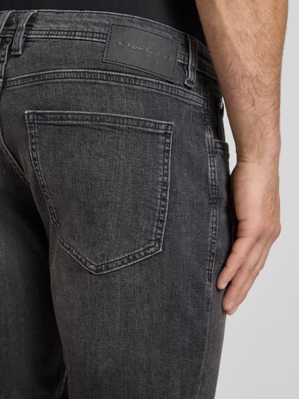 Männermodel trägt Regular Fit Jeans Bermudas aus katoenmix van Tom Tailor, denimlook, labelpatch, detailopname achterkant.