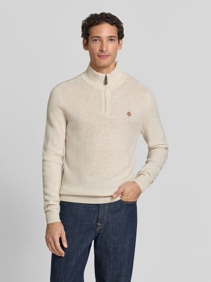Männermodel trägt Regular Fit Strickpullover aus reiner Wolle von MCNEAL in Beige, Logo-Stickerei, Troyer-Kragen, Struktur, Ganzkörperansicht von vorne.