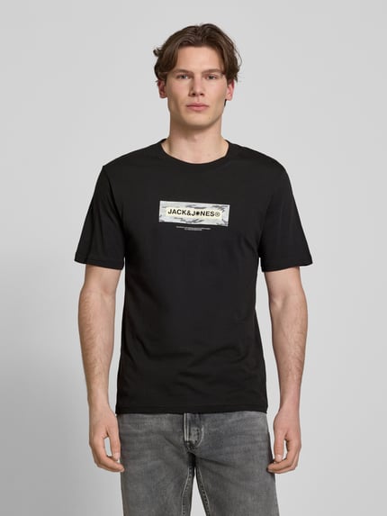 Männermodel trägt T-Shirt mit Logo und Rundhalsausschnitt von Jack & Jones in Schwarz, Regular Fit, reine Baumwolle, Ganzkörperansicht von vorne.
