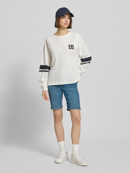 Vrouwenmodel draagt Regular Fit Bermuda in Denim-Optik van Levi's®, blauwe kleur, 5-pocket-design, elastische katoenmix, geheel vooraanzicht.