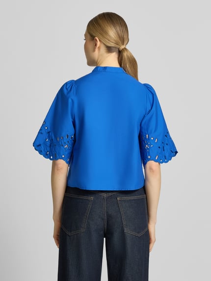 Vrouwenmodel draagt Regular Fit blouse met ajourwerk model 'Marika' van GUIDO MARIA KRETSCHMER WOMAN, puur katoen, halflange mouwen, opstaande kraag, knoopsluiting, ruglengte maat 36: 50 cm, mouwlengte maat 36: 32 cm, helderblauw, rechte vormen, gladde en geborduurde textuur, geheel achteraanzicht.