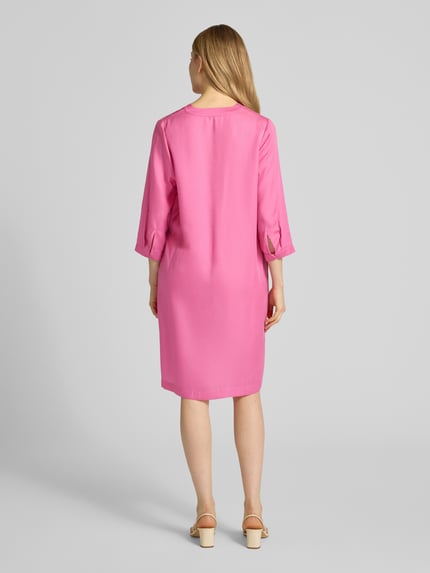 Frauenmodel trägt Knielanges Tunikakleid aus Lyocell von Lanius in Pink, gerader Schnitt, V-Ausschnitt, 3/4-Arm, glatte Textur, Ganzkörperansicht Rückansicht.