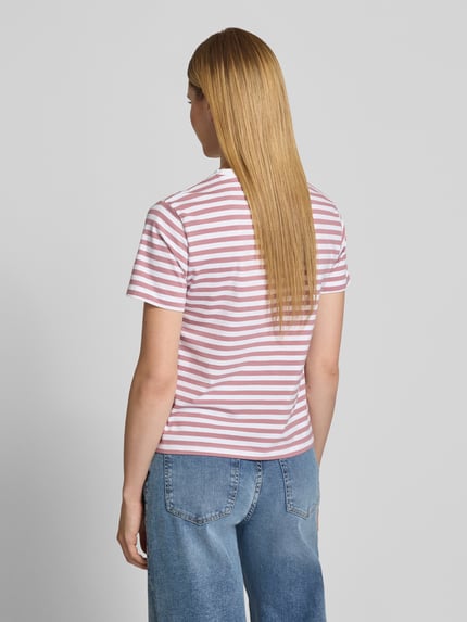 Frauenmodel trägt T-Shirt mit Rundhalsausschnitt Modell 'NORA' von VILA, weiß-rosa gestreift, Baumwoll-Elasthan-Mix, Regular-Fit, Rückenlänge 57 cm, Ganzkörperansicht Rückansicht.