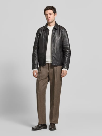 Männermodel trägt Regular Fit Bundfaltenhose aus Wolle von Selected Homme mit Fischgrätenstruktur, Gürtelschlaufen, Webware, Ganzkörperansicht von vorne.