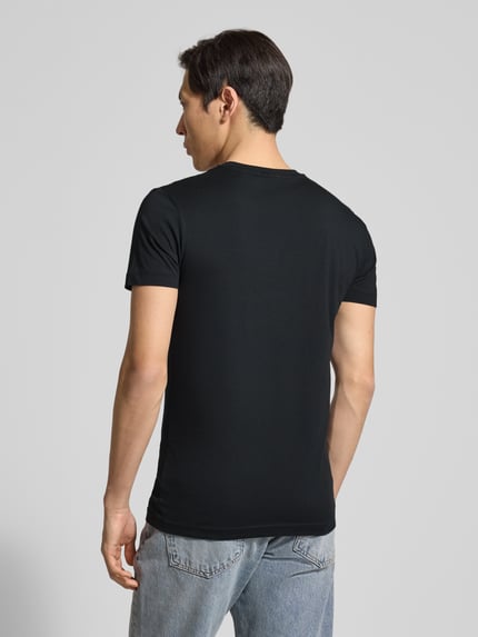 Männermodel trägt T-Shirt mit Label-Detail von Gant aus reiner Baumwolle, schwarzer Stoff, gerader Schnitt, Rückenansicht, Ganzkörperansicht Rückansicht.