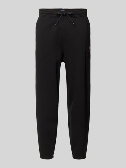 Produktfoto, Regular Fit Sweatpants aus Baumwoll-Mix von Tommy Jeans in Optik: Unifarben mit elastischem Bundabschluss, Label-Stitching-Applikation, Tunnelzug-Verschluss, seitlichen Eingrifftaschen, Gesäßtasche und Sweat-Materialverarbeitung.