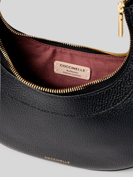 Produktfoto, schwarze Shoulder Bag mit Strukturmuster Modell 'Whisper' von Coccinelle, Reißverschluss, goldene Details, Nahaufnahme Innenansicht, Hauptfach mit Futter, Kontext: Damen Shoulder Bag, italienisches Leder, verstellbarer Schulterriemen, Größe 24x24x6 cm, Schulterriemenlänge 58 cm.