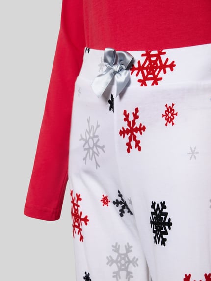 Frauenmodel trägt Pyjama mit Schleifen-Detail Modell 'Winterzauber' von LOUIS & LOUISA, rote und graue Schneeflocken auf Weiß, reine Baumwolle, Nahaufnahme Hüfte, KI-modifiziertes Bild